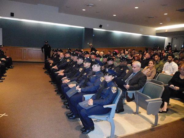 police officers and civilians in an auditorium